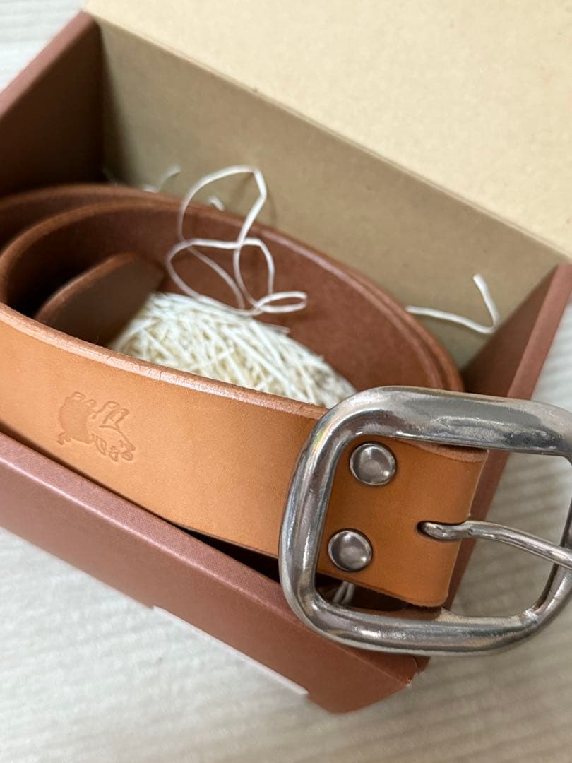 ダルチザンのご神体とアベニューコタローの刻印入りの、シンプルなバックルのベルト