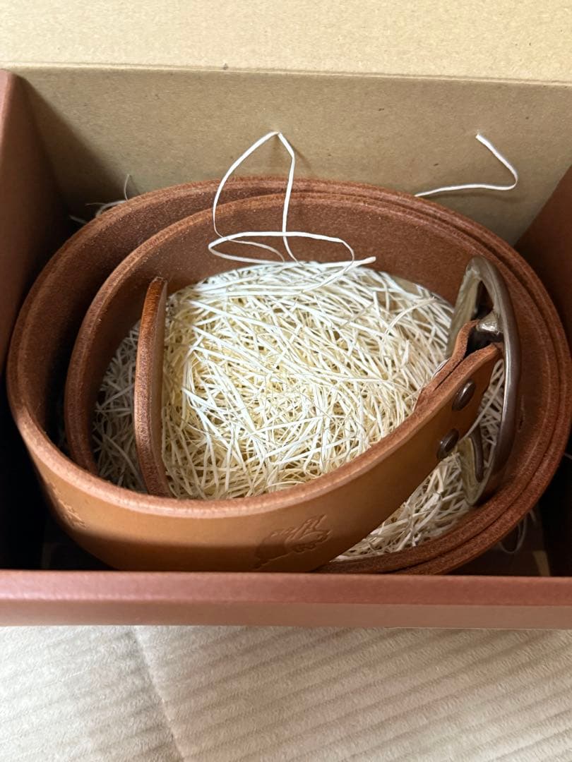 ダルチザンのご神体とアベニューコタローの刻印入りの、シンプルなバックルのベルト