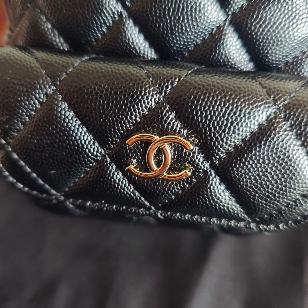 キルティングデザインのブラックバックパック、ダブルCロゴ付き。