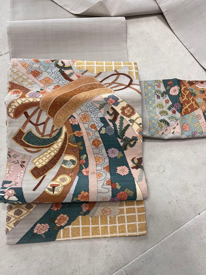 仕立て上がり新品袋帯　薄いグレーに鶴松花宝尽くしなどおめでたい柄　とても可愛い