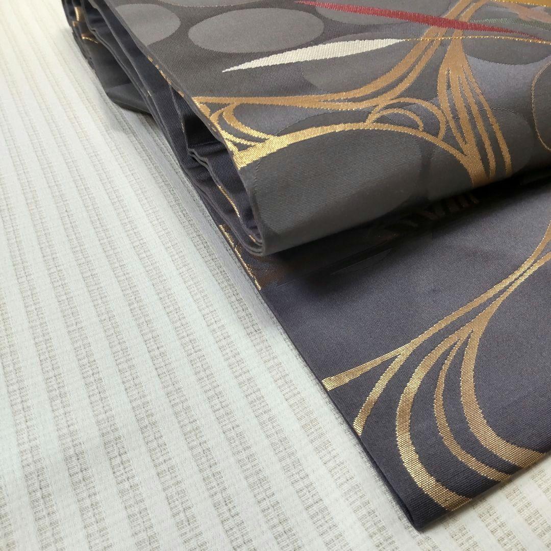 【名古屋帯】未使用品✣クールに流れる金の曲線｜チャコールグレー 流水 358cm