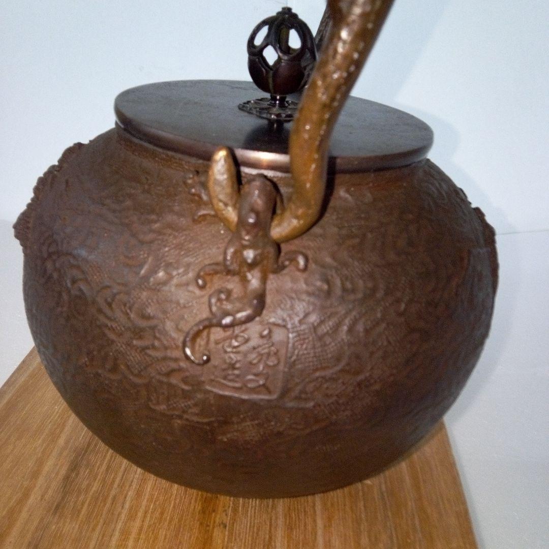 亀文堂造　鉄瓶　楼閣山水盛上紋様　霊芝銅持手