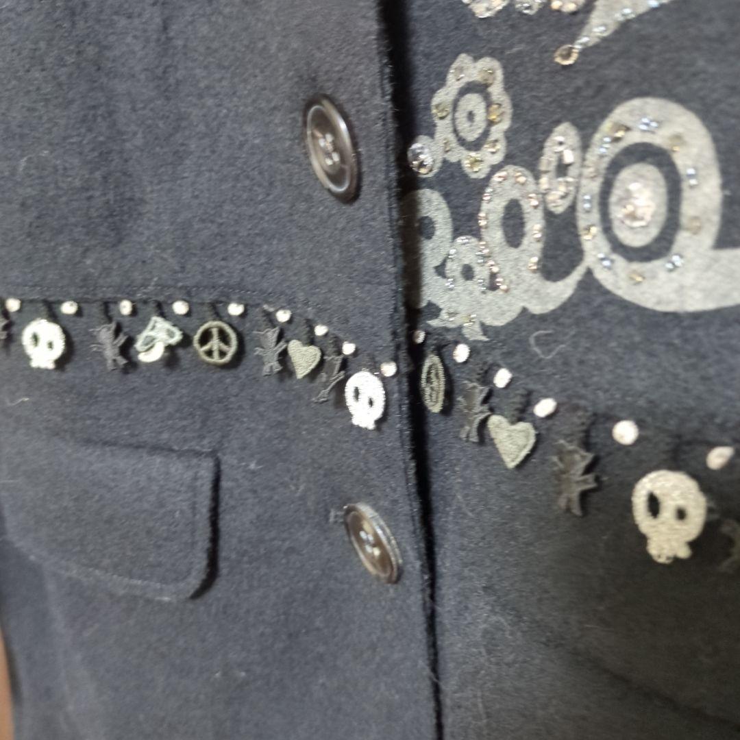 黒い装飾付きチェスターコート、白のファー付きベスト