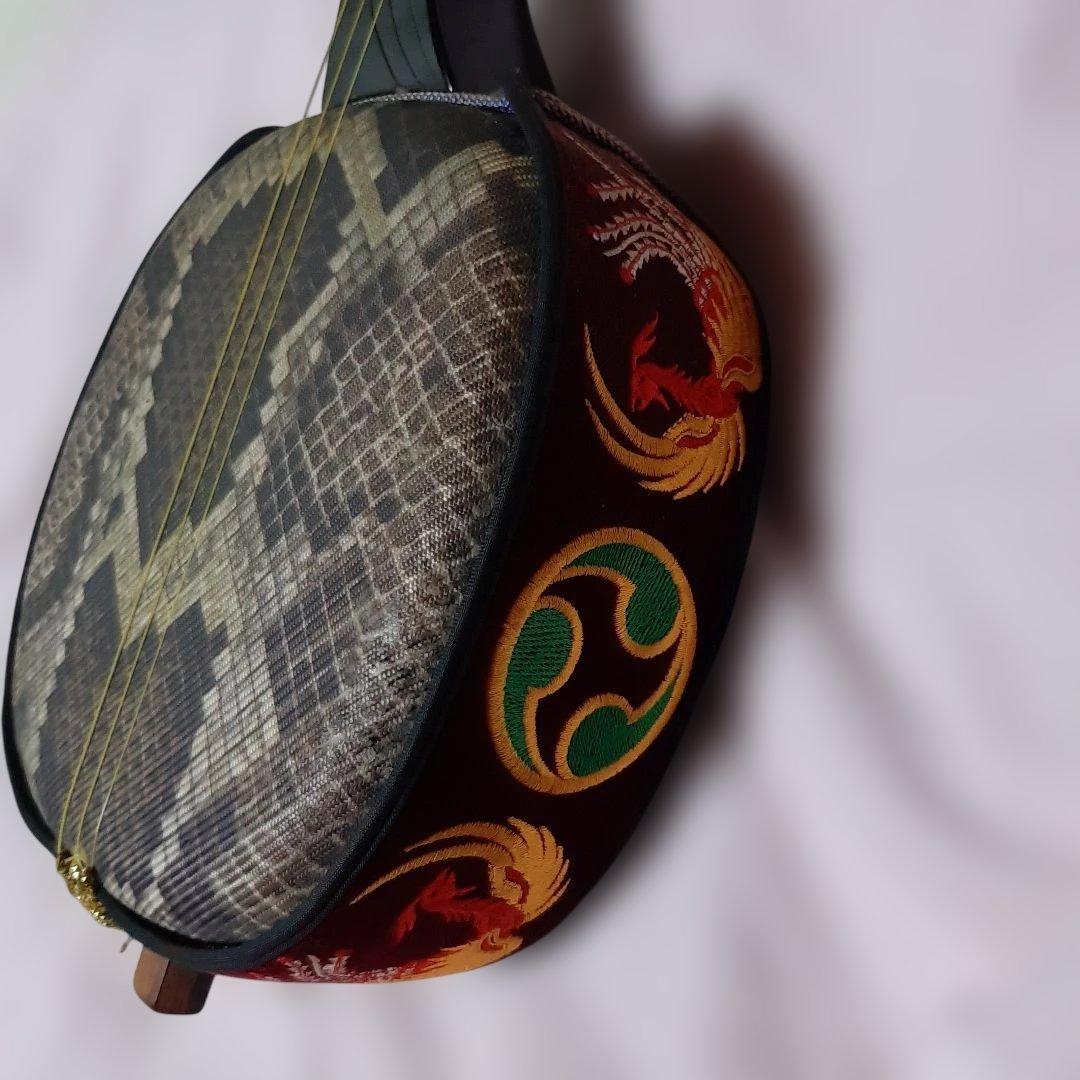 特上沖縄三線◆蛇柄デザイン人工皮革製◆手掛け金色刺繍左三つ巴◆ハードケース付き