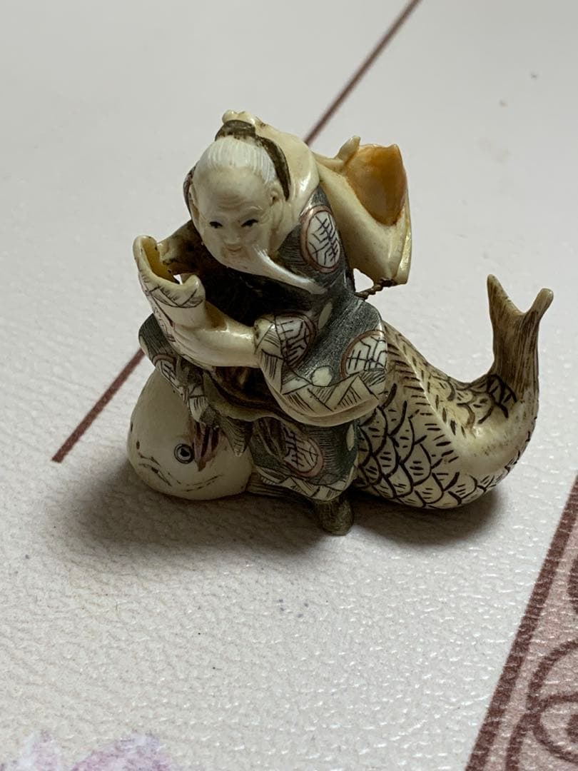 天然素材根付けアンティーク品寿老人と魚彫ってます。