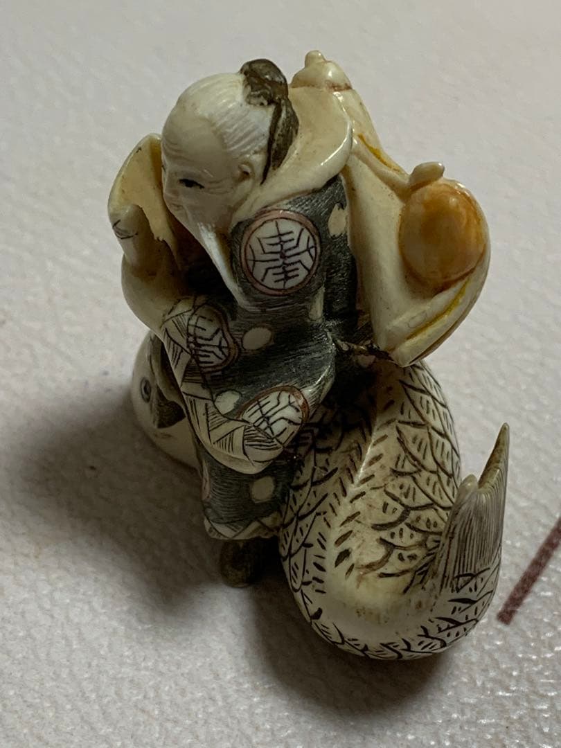 天然素材根付けアンティーク品寿老人と魚彫ってます。