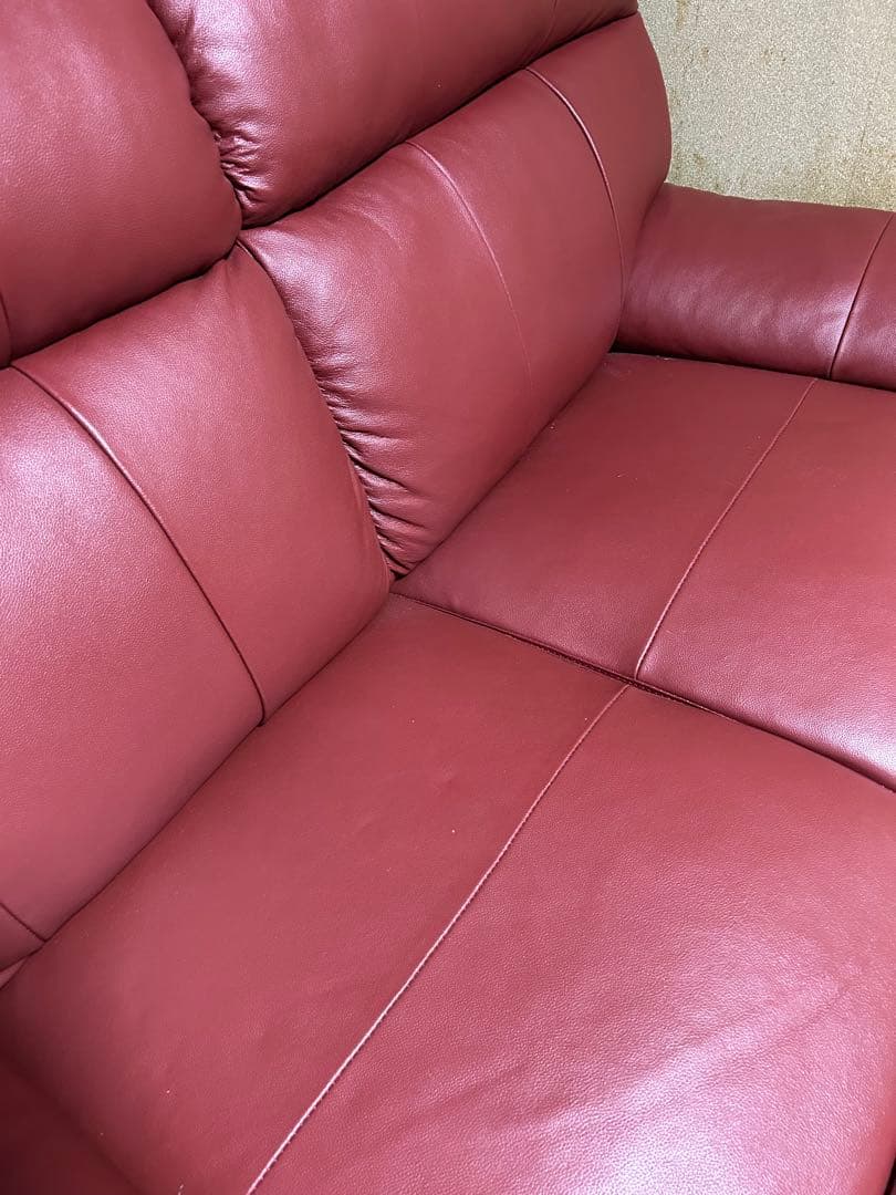赤い合成皮革の2人掛けソファとオットマン
