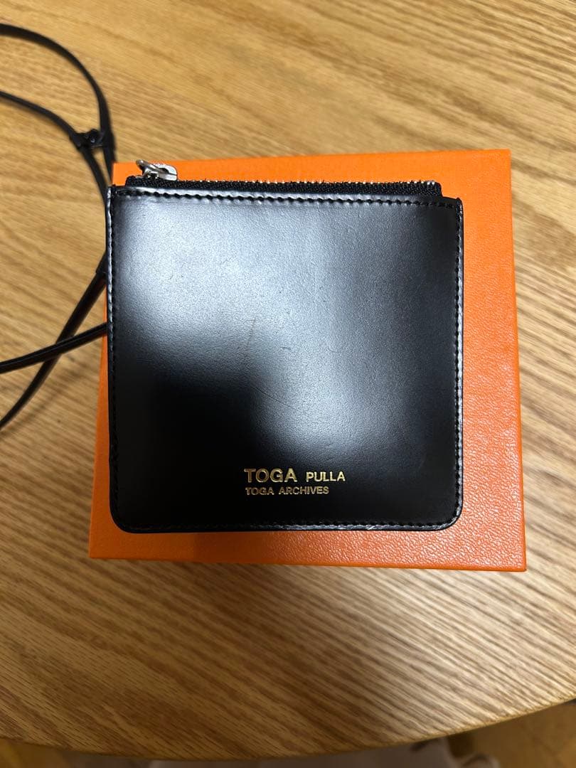 ブラックのレザー製二つ折り財布TOGA PULLA