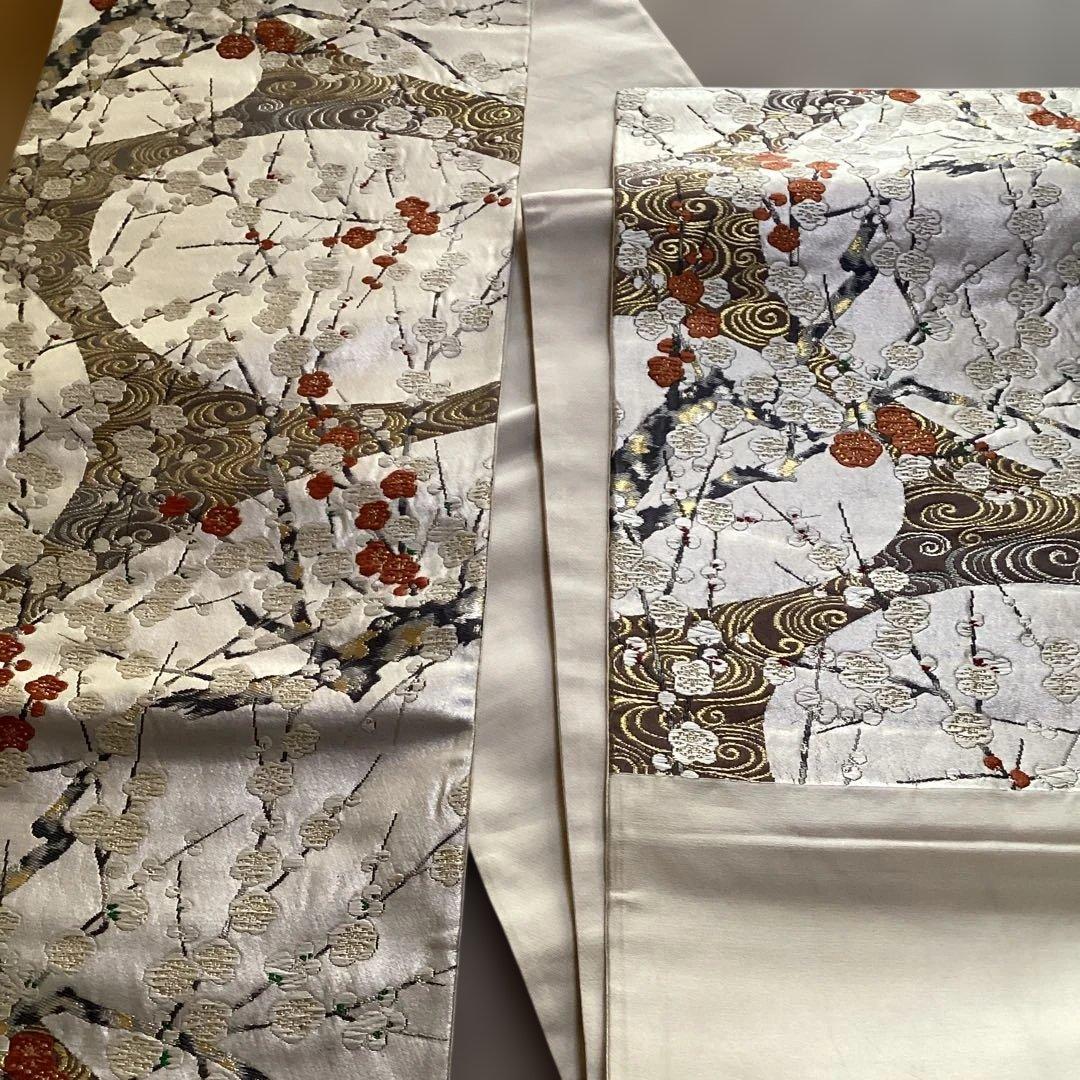 高級袋帯　唐織　シルバーの正絹の生地に刺繍のような浮き上がった紅白の梅　逸品