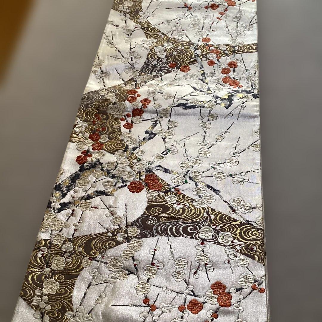 高級袋帯　唐織　シルバーの正絹の生地に刺繍のような浮き上がった紅白の梅　逸品