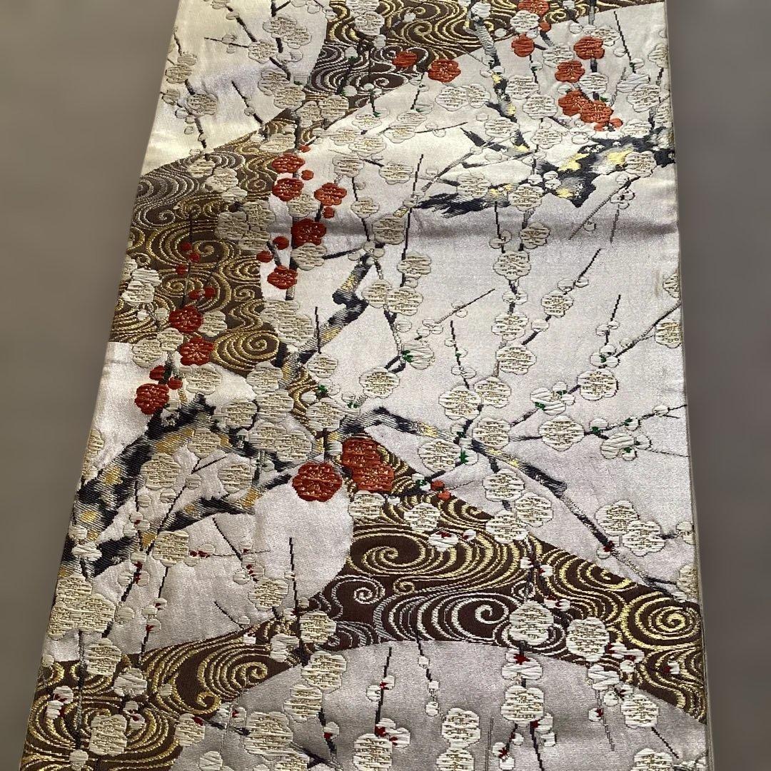 高級袋帯　唐織　シルバーの正絹の生地に刺繍のような浮き上がった紅白の梅　逸品