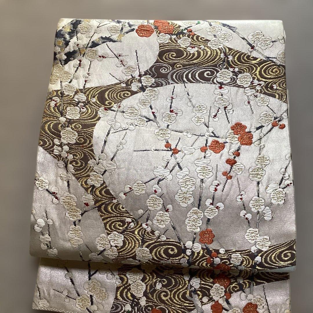 高級袋帯　唐織　シルバーの正絹の生地に刺繍のような浮き上がった紅白の梅　逸品
