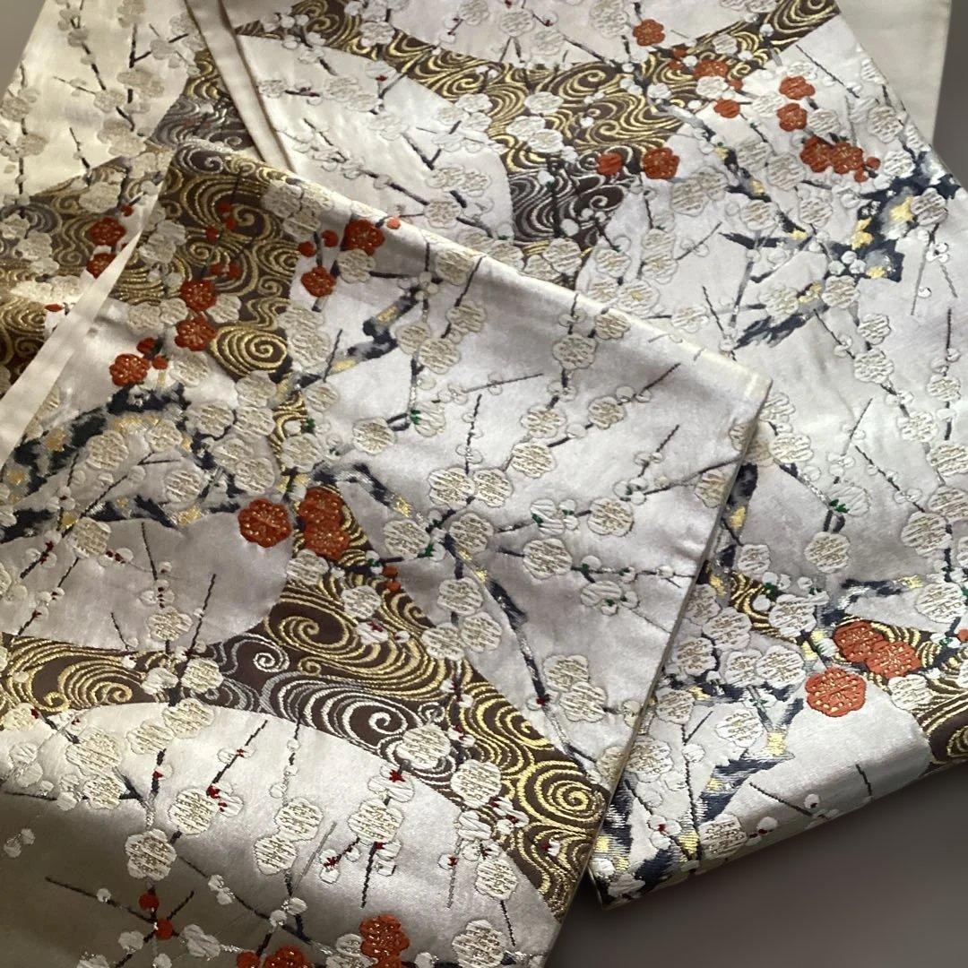 高級袋帯　唐織　シルバーの正絹の生地に刺繍のような浮き上がった紅白の梅　逸品