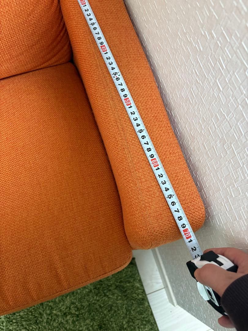 オレンジ色の3人掛けソファ